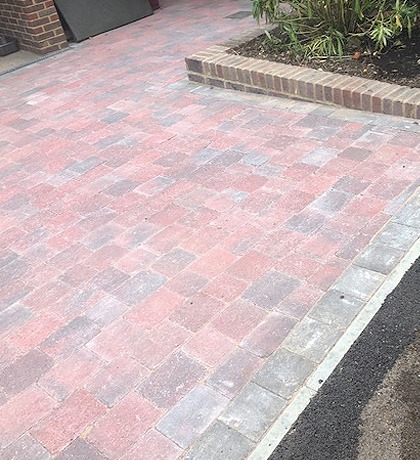 Close view of finished red brindle block paving beside a raised brick bed