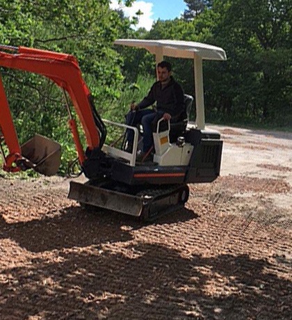 A mini digger on a stripped-back area of ground