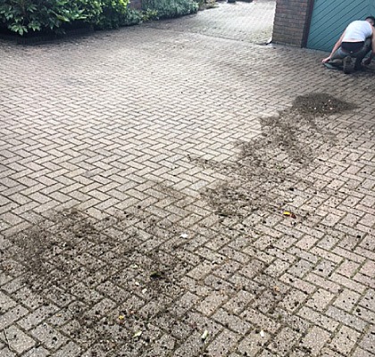 An older block-paved drive halfway through being pressure washed