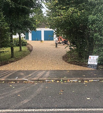 The finished gravel drive running up from the road to the garages