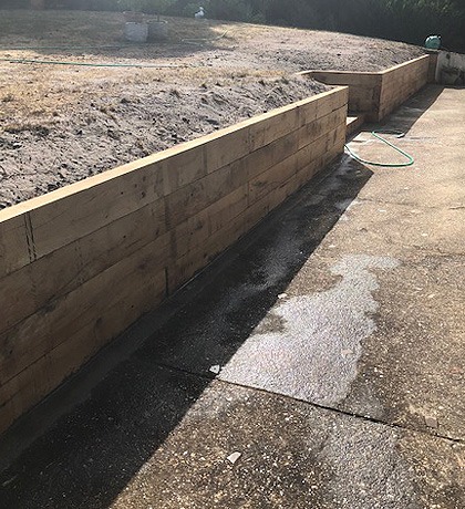 The finished sleeper retaining wall holding back a raised bed