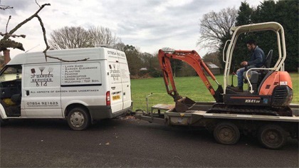 The JF van towing a mini digger on a plant trailer